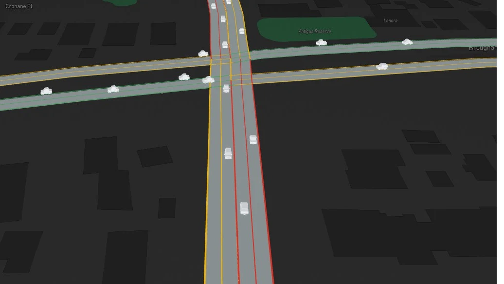 3D simulation close-up: vehicles moving through a junction, with buildings on